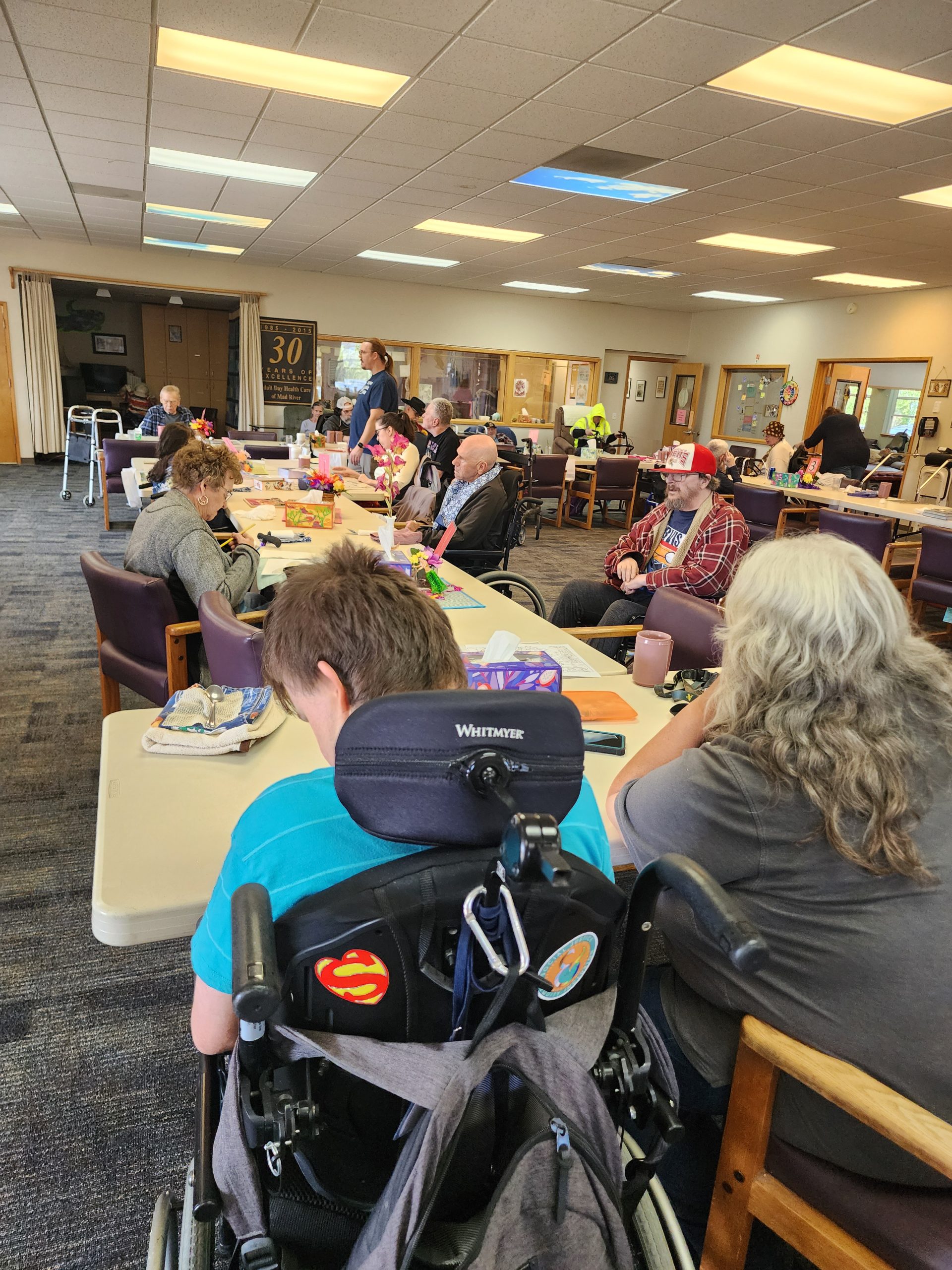 A room full of people seated at tables.